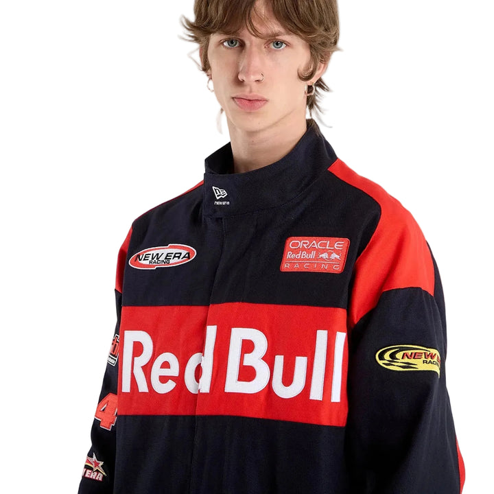 Close-up front view of a male model wearing the New Era Red Bull Racing jacket with embroidered chest and sleeve patches.