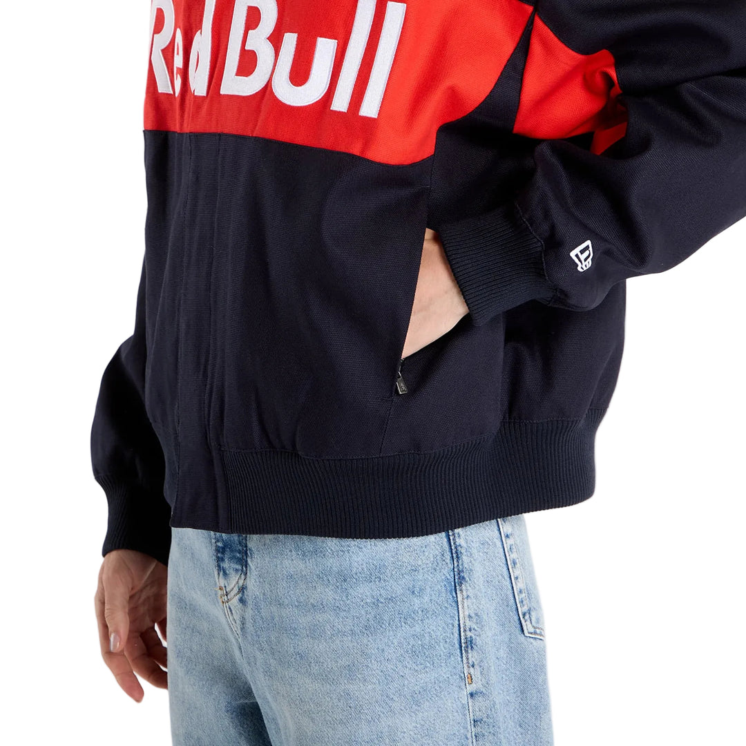 Close-up of the side pocket with New Era stitched flag, elasticated hem and black canvas fabric on the New Era Red Bull Racing motorsport jacket.