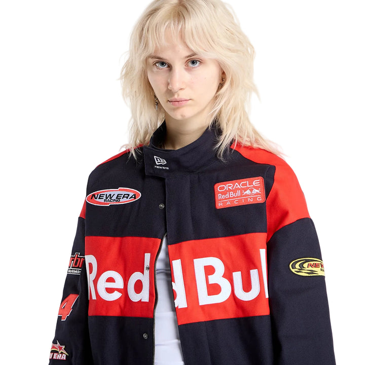Woman modelling the New Era Oracle Red Bull Racing black canvas jacket, highlighting the red chest panel and motorsport patches.