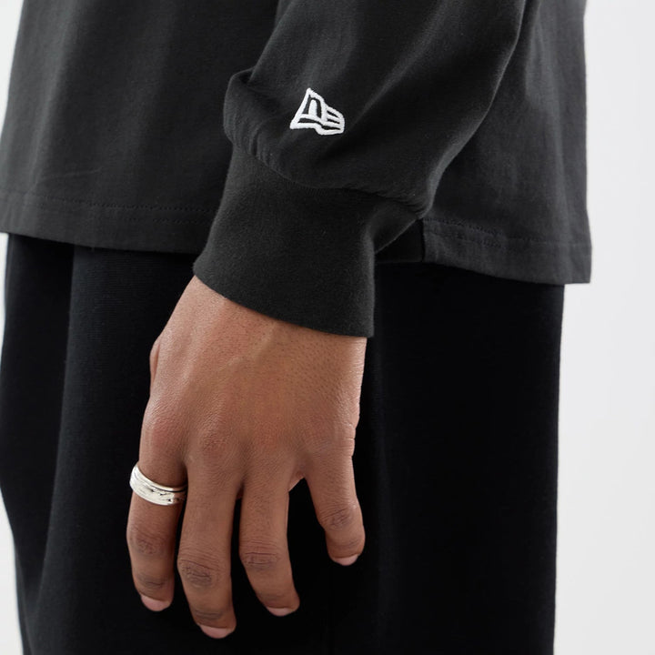 Close-Up of a New Era flag logo embroidered on the cuff of a black Williams Racing Las Vegas GP long-sleeve shirt.