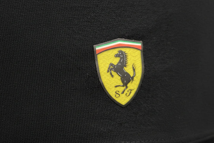 Close-up of official Scuderia Ferrari shield logo heat-pressed on women’s black F1 t-shirt hem