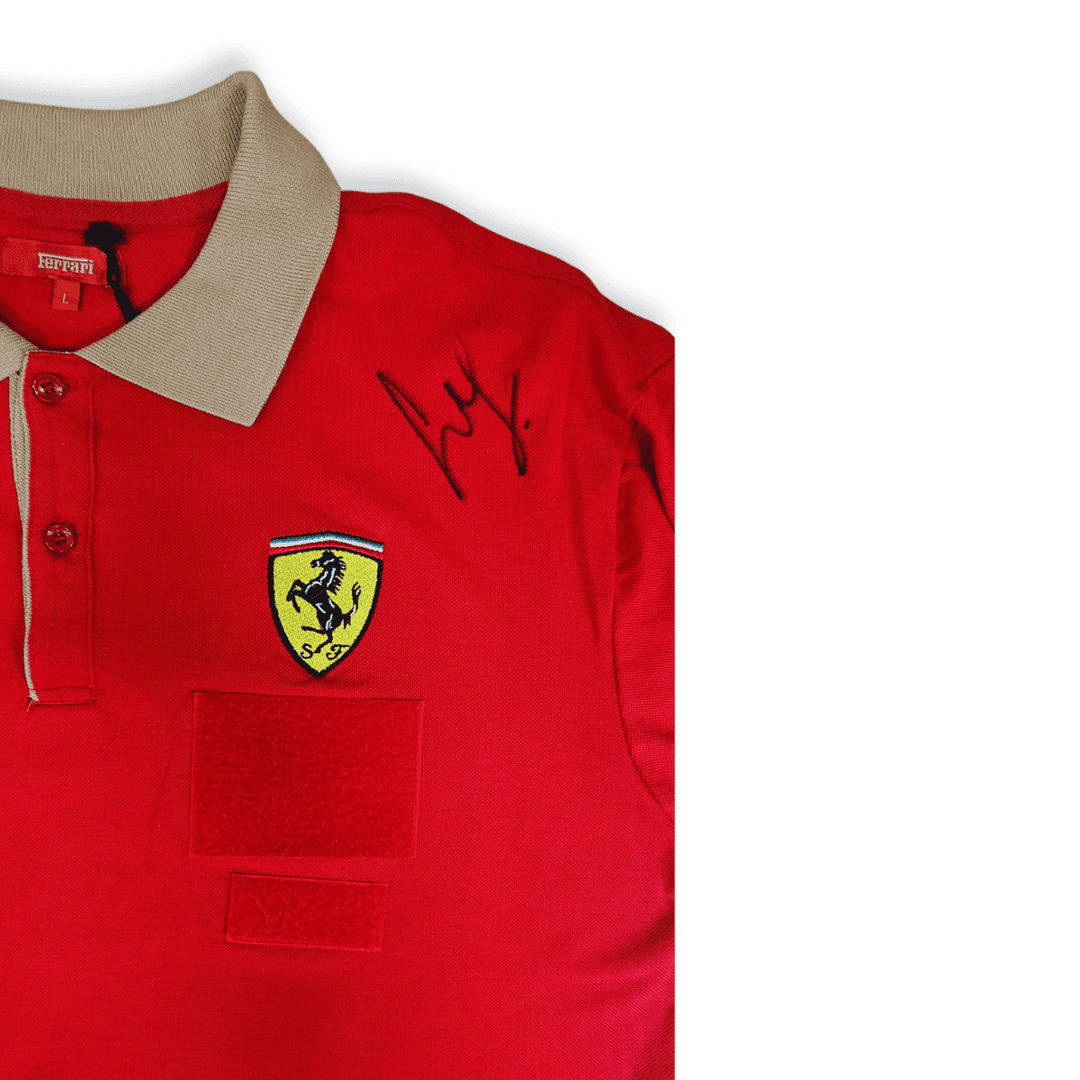 An original, curated red Scuderia Ferrari technical team men's polo shirt, sourced from Maranello, Italy, directly from the Team, with a sandy brown collar, featuring official Prancing Horse embroidery and the autographs of Scuderia Ferrari F1 Team Driver Carlos Sainz on the left shoulder, next to the employee team velcro patches. 