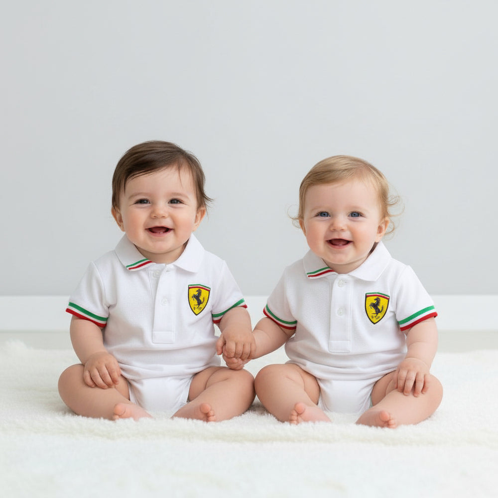 Two babies wearing white officially licensed Scuderia Ferrari white polo shirts with Italian Tipped Sleeves on a studio background 