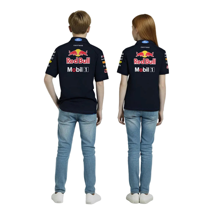 Two kids, a boy and a girl between the ages of 7 and 12 years old, wearing a 2026 Oracle Red Bull Racing F1 Team Set Up Polo - with sponsor logos on the front and back with a white background by Castore