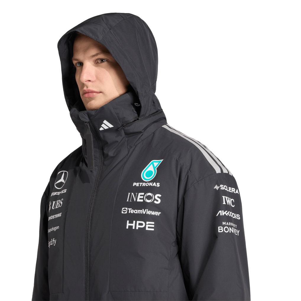 Mercedes F1 fan wearing a Mercedes AMG Petronas adidas F1 2026 Team Jacket - black  with various brand logos on a white background