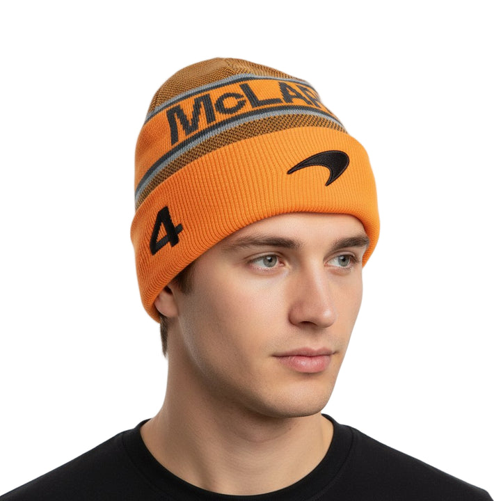 Orange winter beanie with 'LANDO NORRIS WORLD CHAMPION NUMBER 4 MCLAREN' branding worn by an F1 fan on a white background