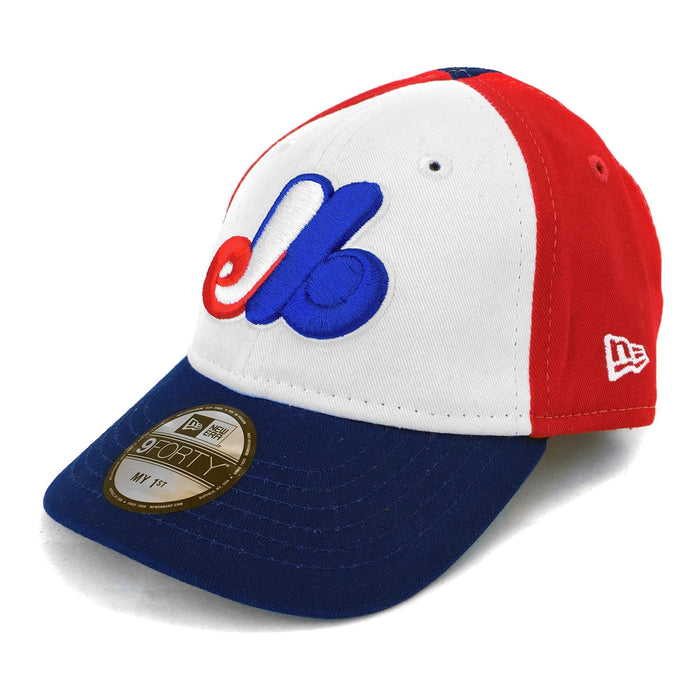 A toddler-sized Montreal Expos baseball cap with the Montreal Expos team logo, featuring a tricolour design with red, white, and blue panels and a curved visor.