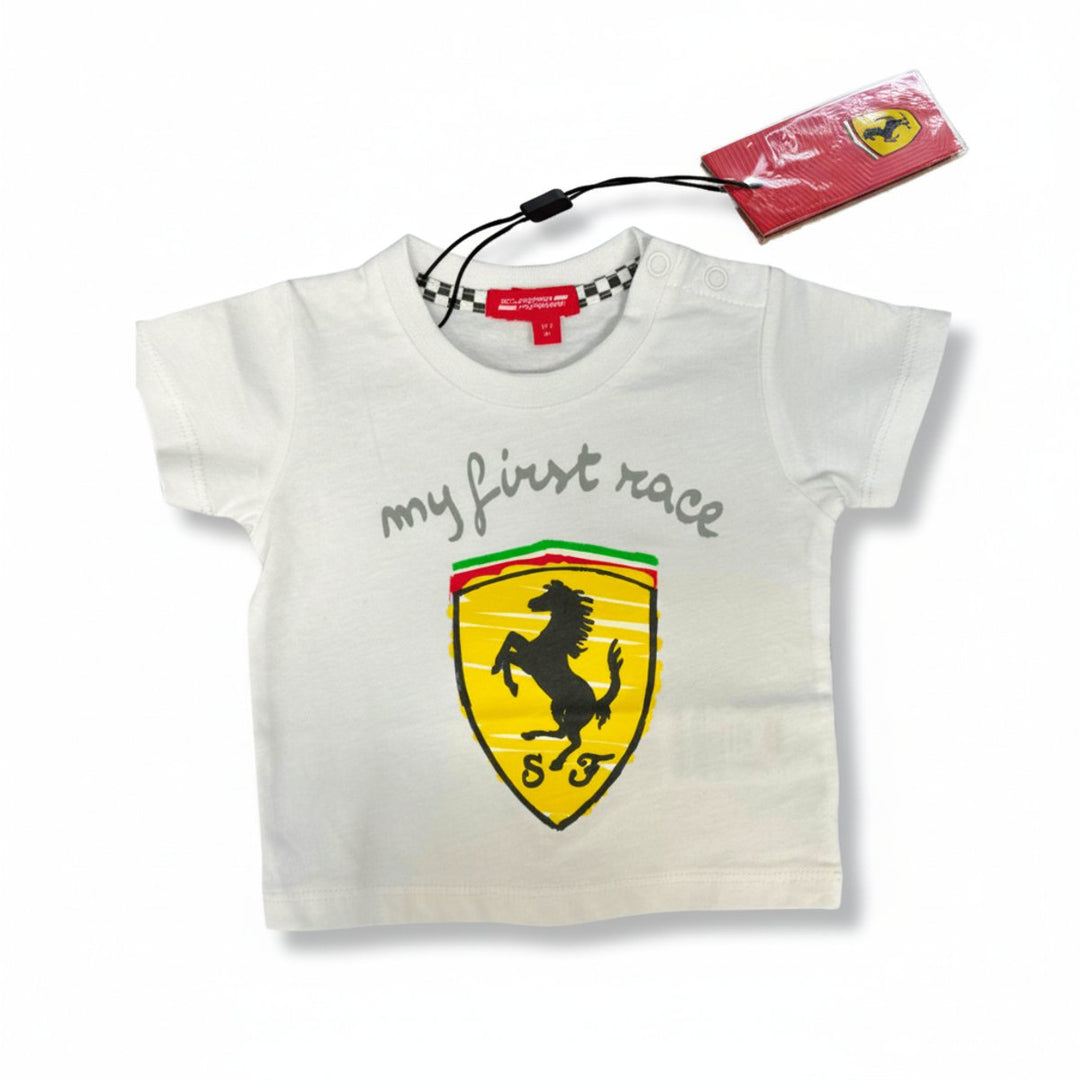 A white Scuderia Ferrari baby T-shirt with a white 'My First Race' text and the iconic Ferrari shield logo on the front. 
