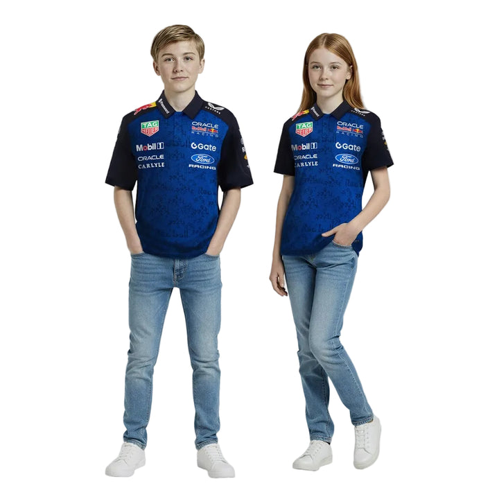 Two children wearing matching blue and Night Sky Oracle Red Bull Racing 2026 F1 Team Set Up Polo shirts with various logos on a white background