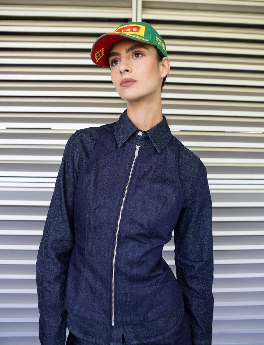 Imagen ambiental de una fanatica celebrando el podio del GP México 2025 con la gorra Pirelli verde puesta por el ganador Lando Norris de McLaren 